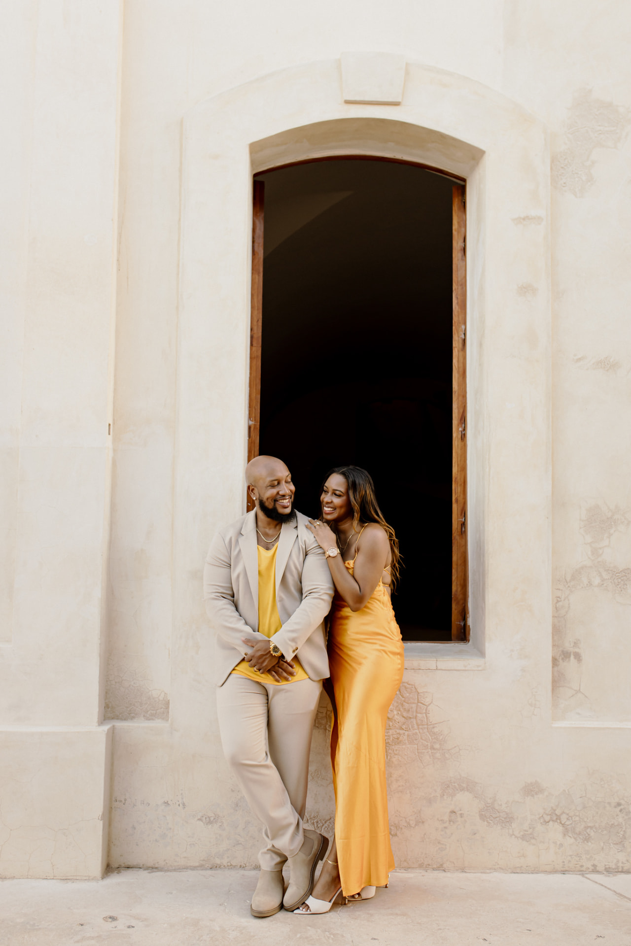 Andrew and his wife laughing together in an archway doorway