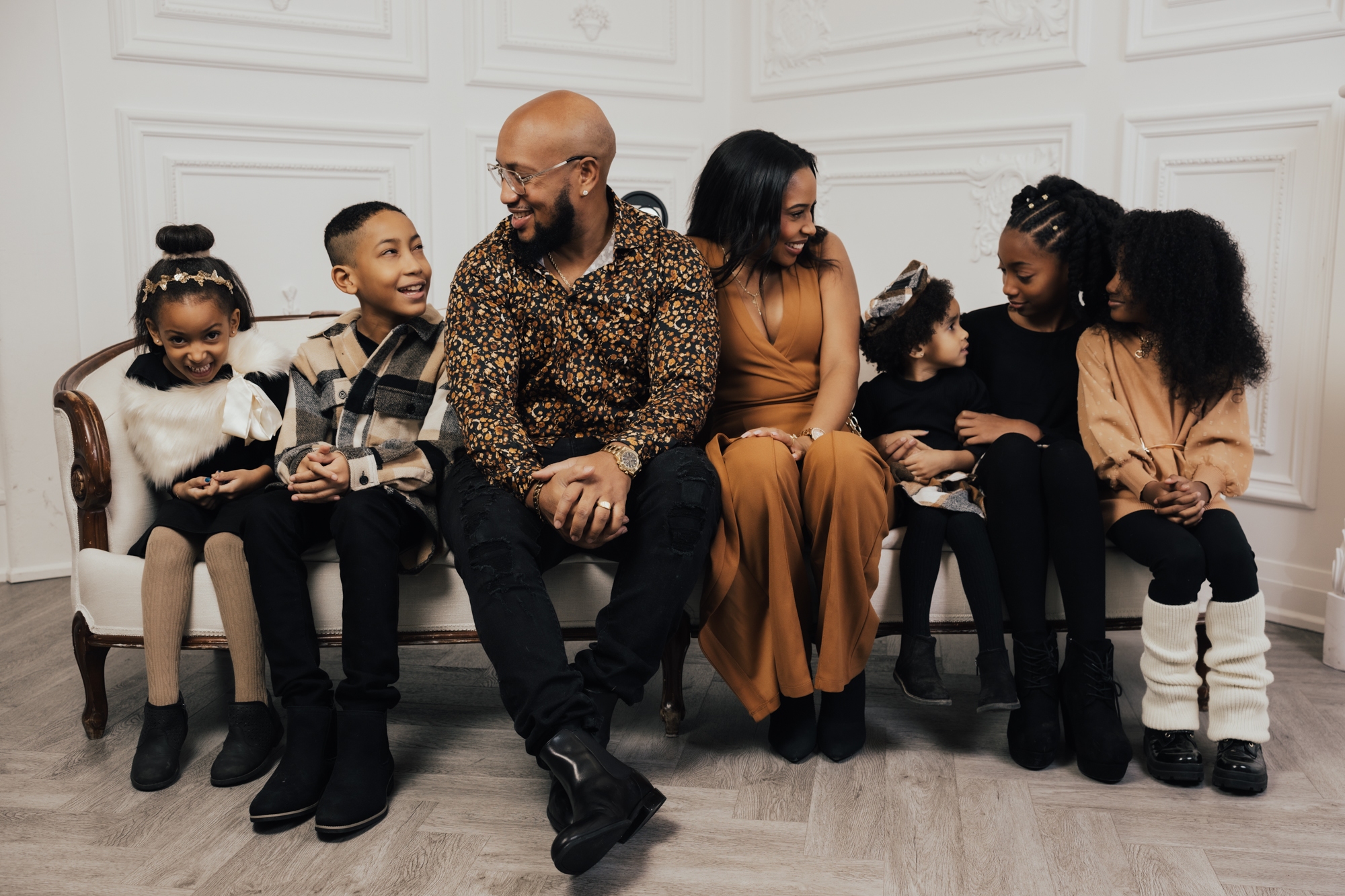The Alleyne family seated together on a cream sofa