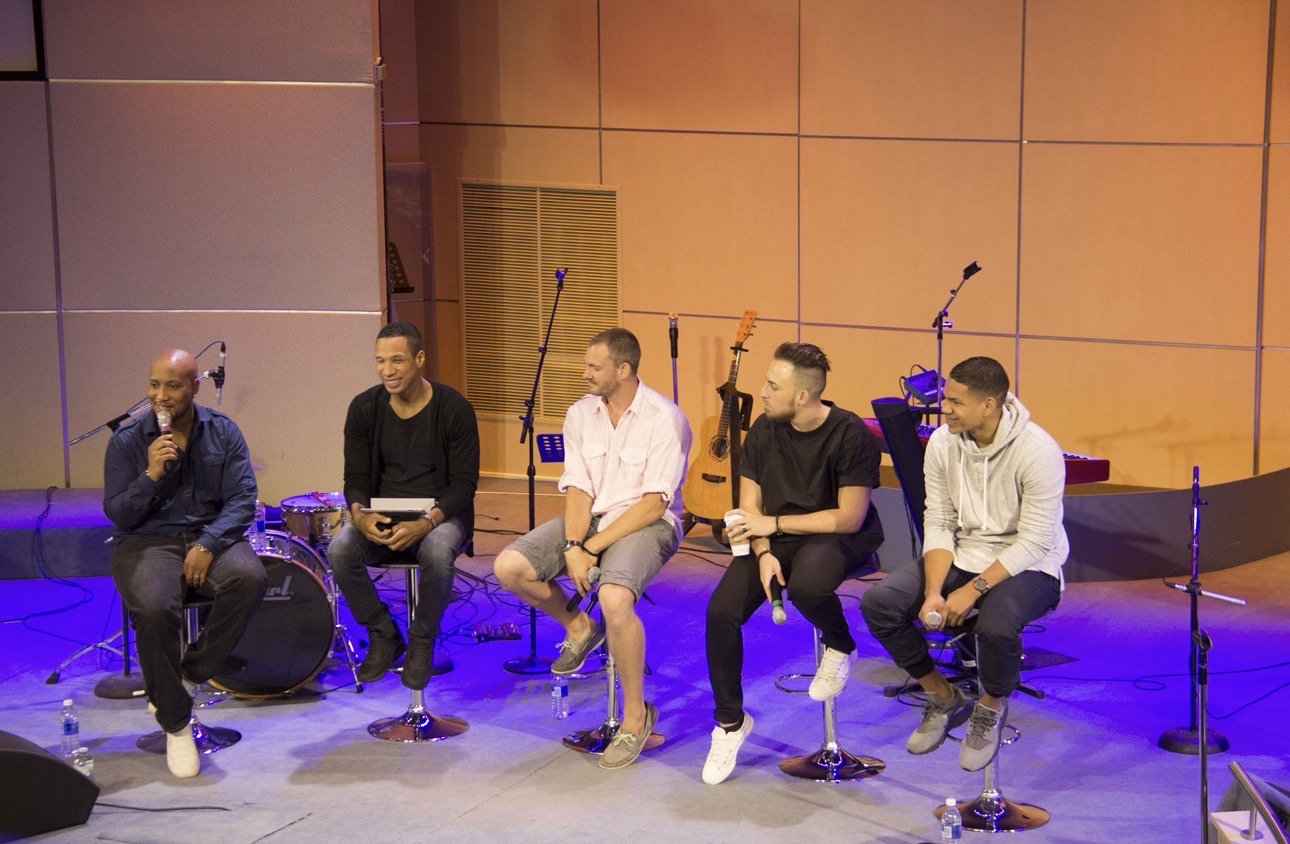 Andrew Alleyne hosting a panel discussion with four guests on stage