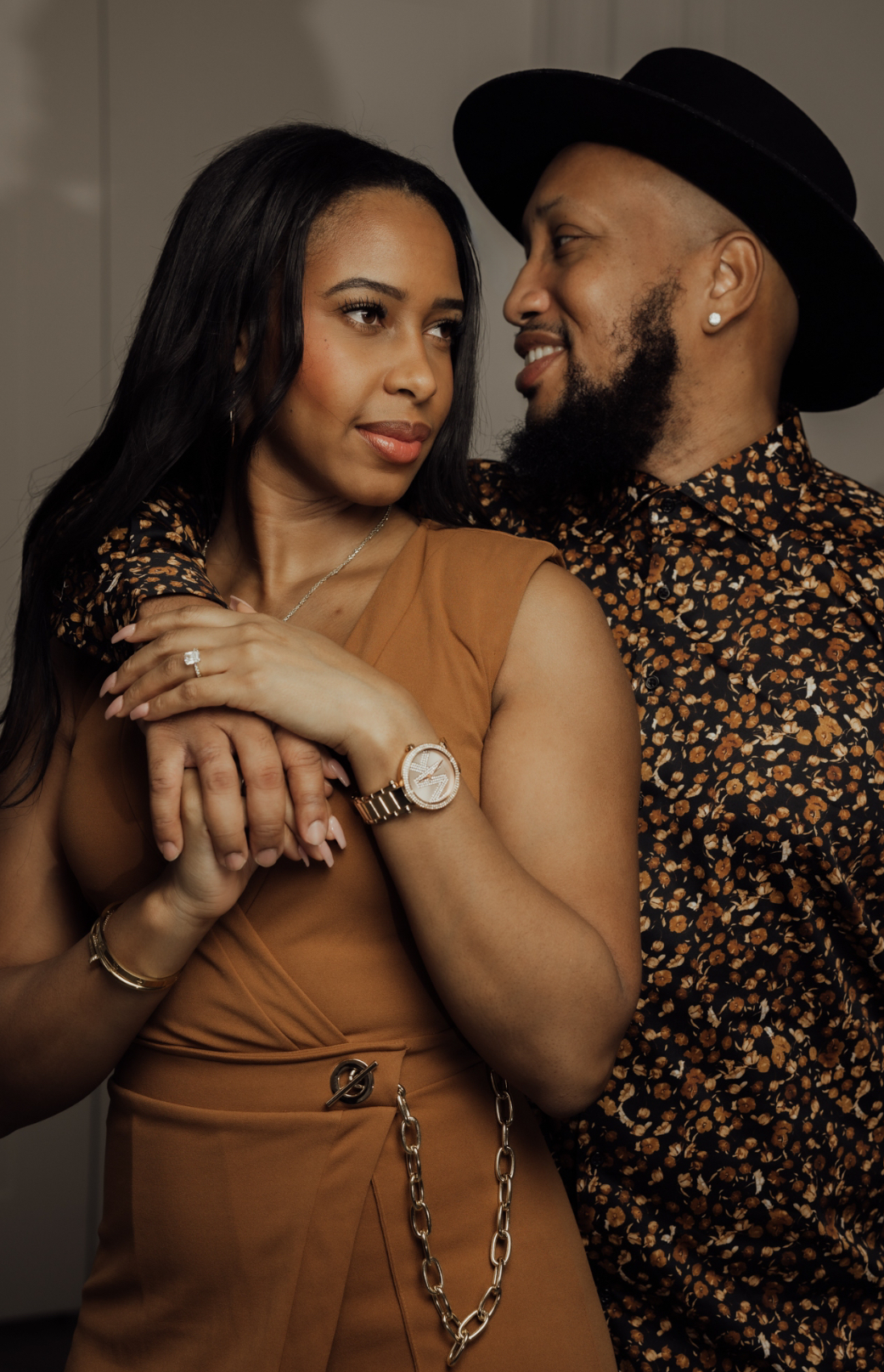Andrew and his wife standing close together in a warm studio portrait