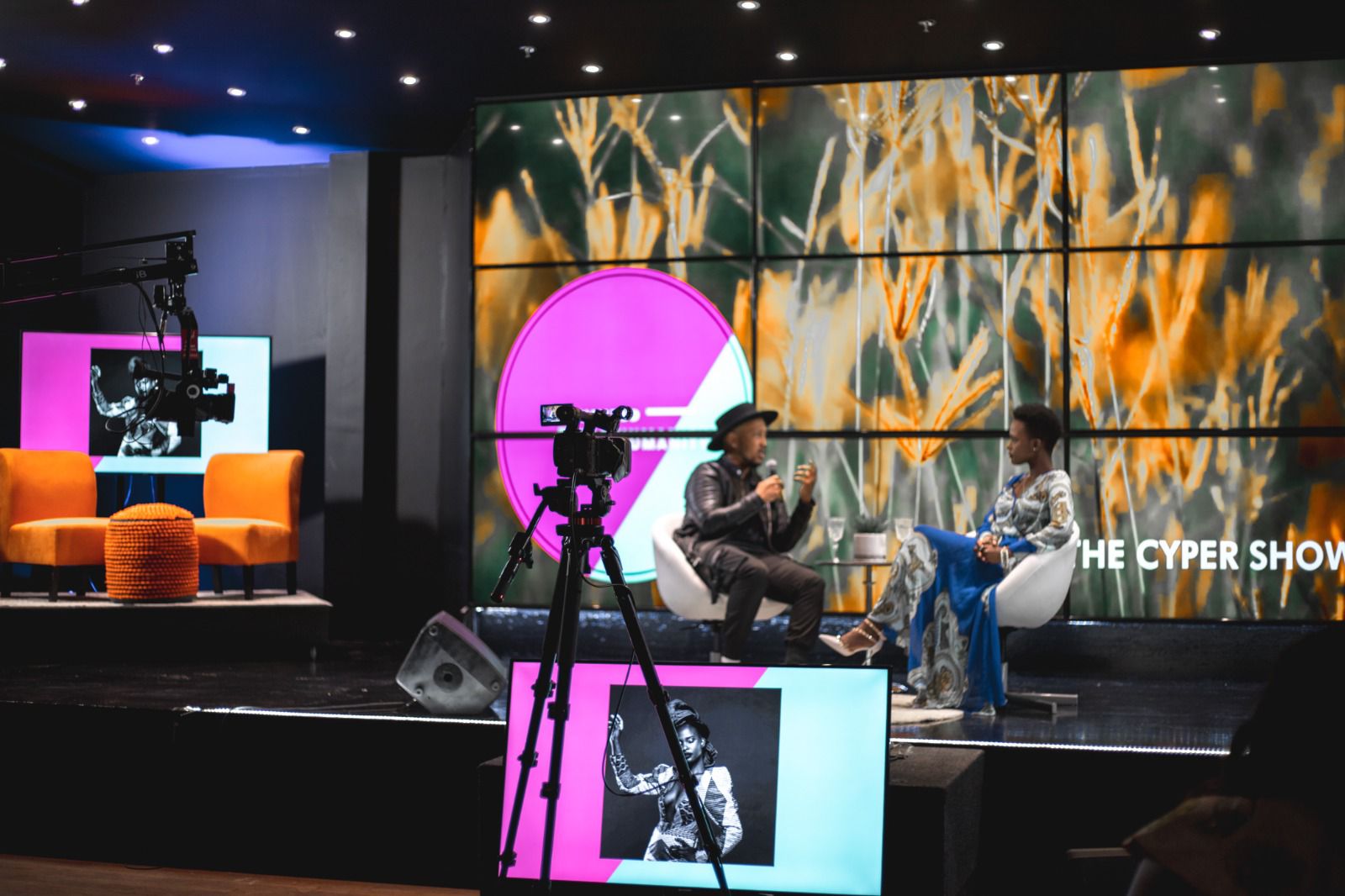 Andrew Alleyne hosting an interview on a studio set