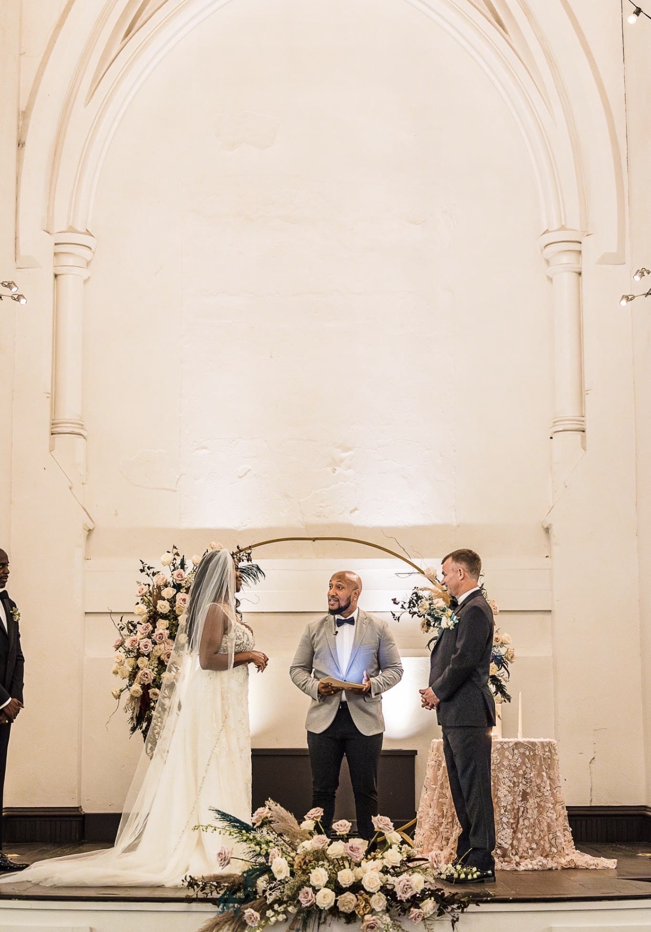 Andrew Alleyne leading a chapel wedding ceremony under a stone arch